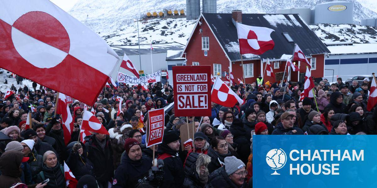 Greenlanders waving the island's flag in Nuuk to protest US ambitions to acquire the territory