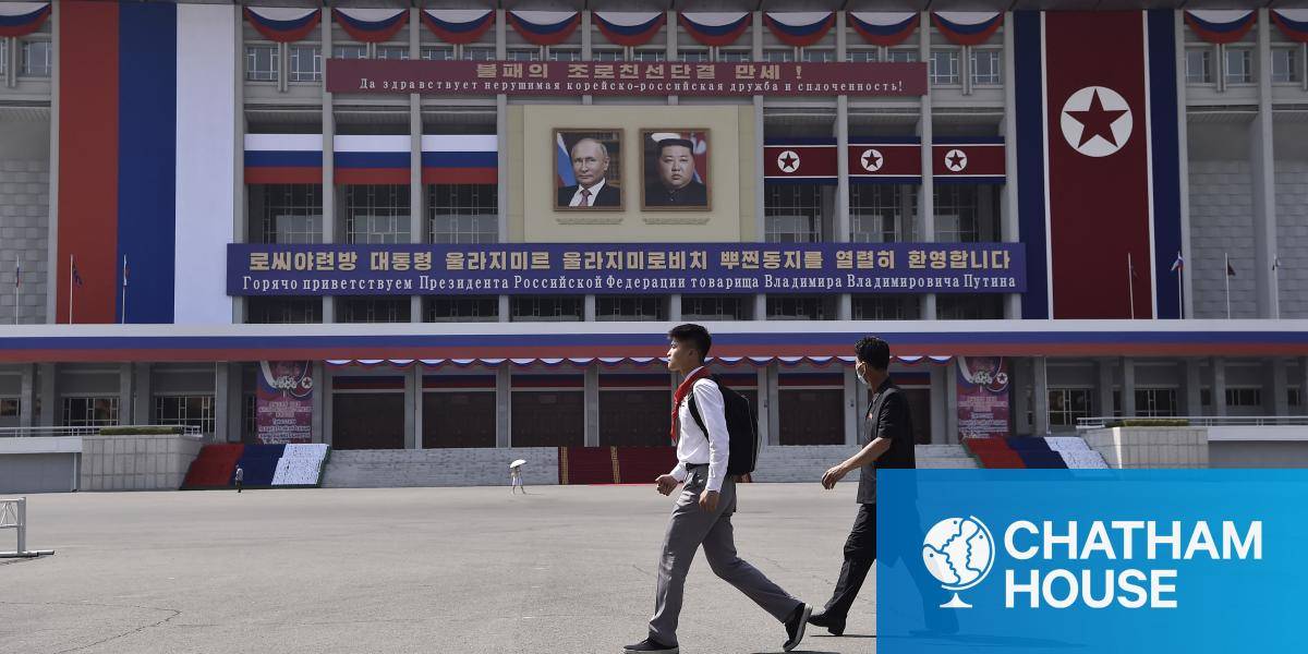 People walk past banners of Russian President Vladimir Putin and North Korean leader Kim Yong Un in Pyongyang in 2024