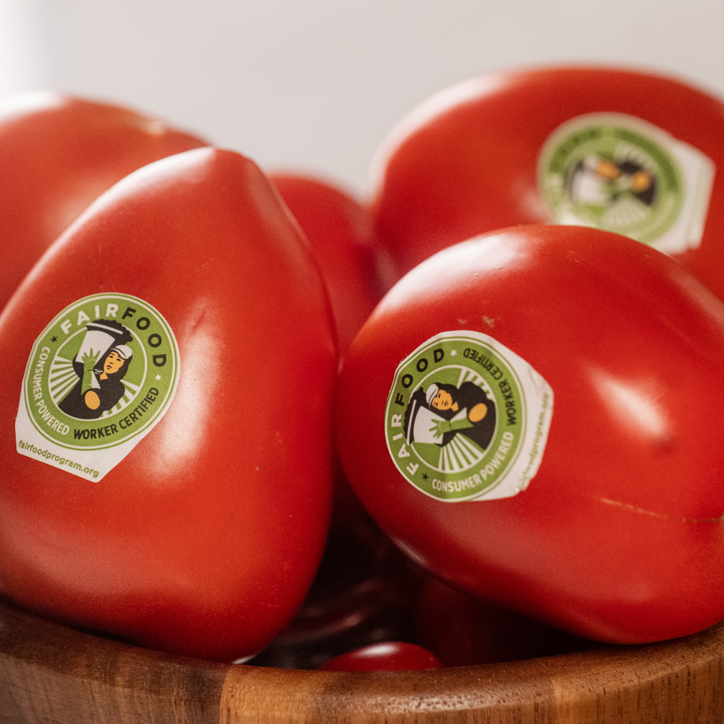 Tomatoes with “Fair Food” stickers in a wooden bowl.