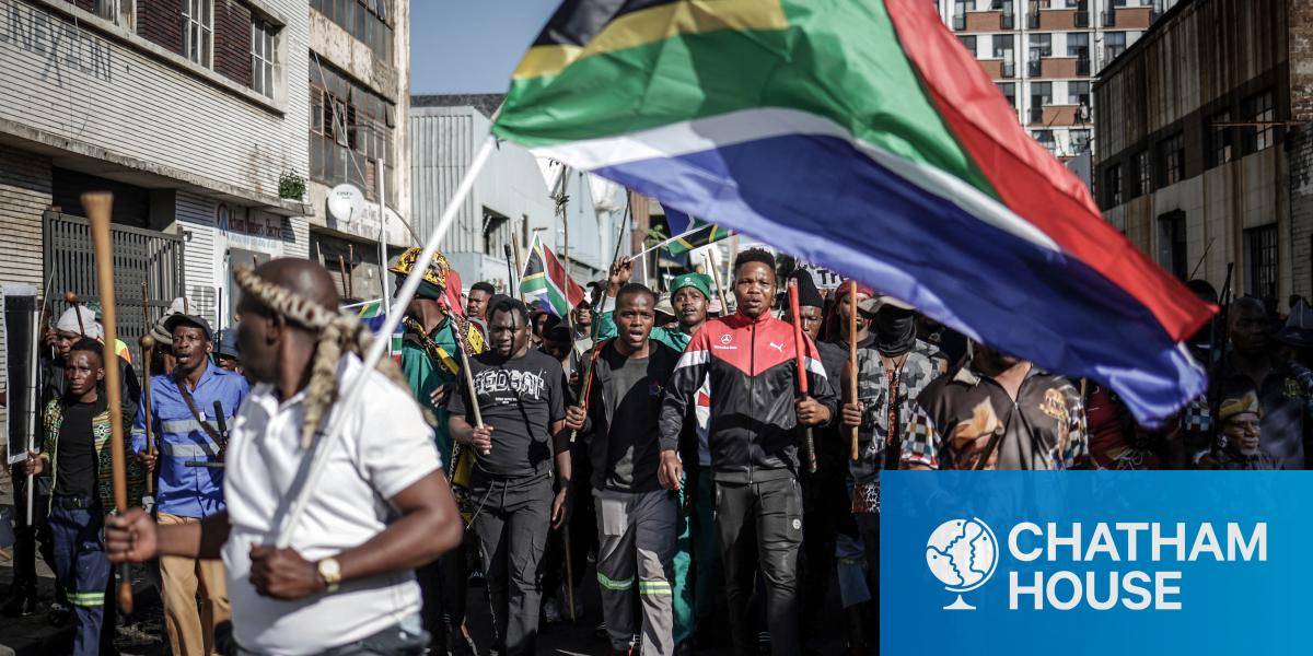 Group of protestors march with the South African flag
