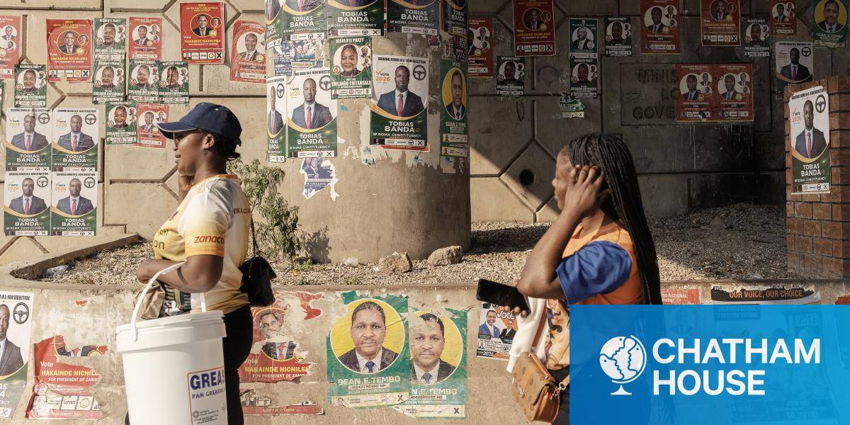 Two women walk past electoral campaign posters in Lusaka, on 9 August 2026. 