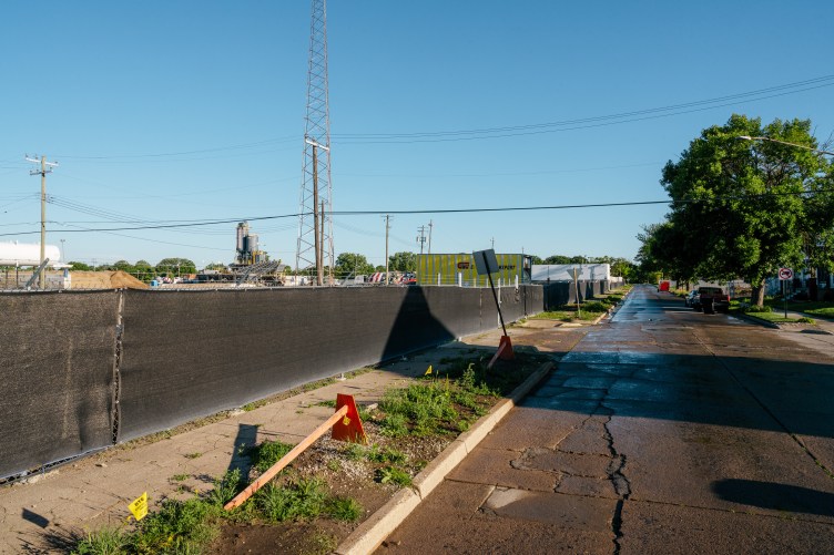 A page from a document that says “Kronos Concrete, LLC” and has two images, labeled “before” and “after.” The before image is a vacant lot that in the after image is instead a grassy, tree-lined hillside.