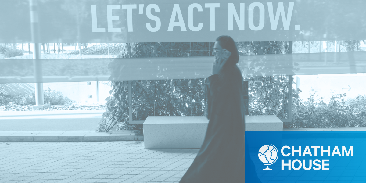 Woman walks past sign saying 'let's act now'