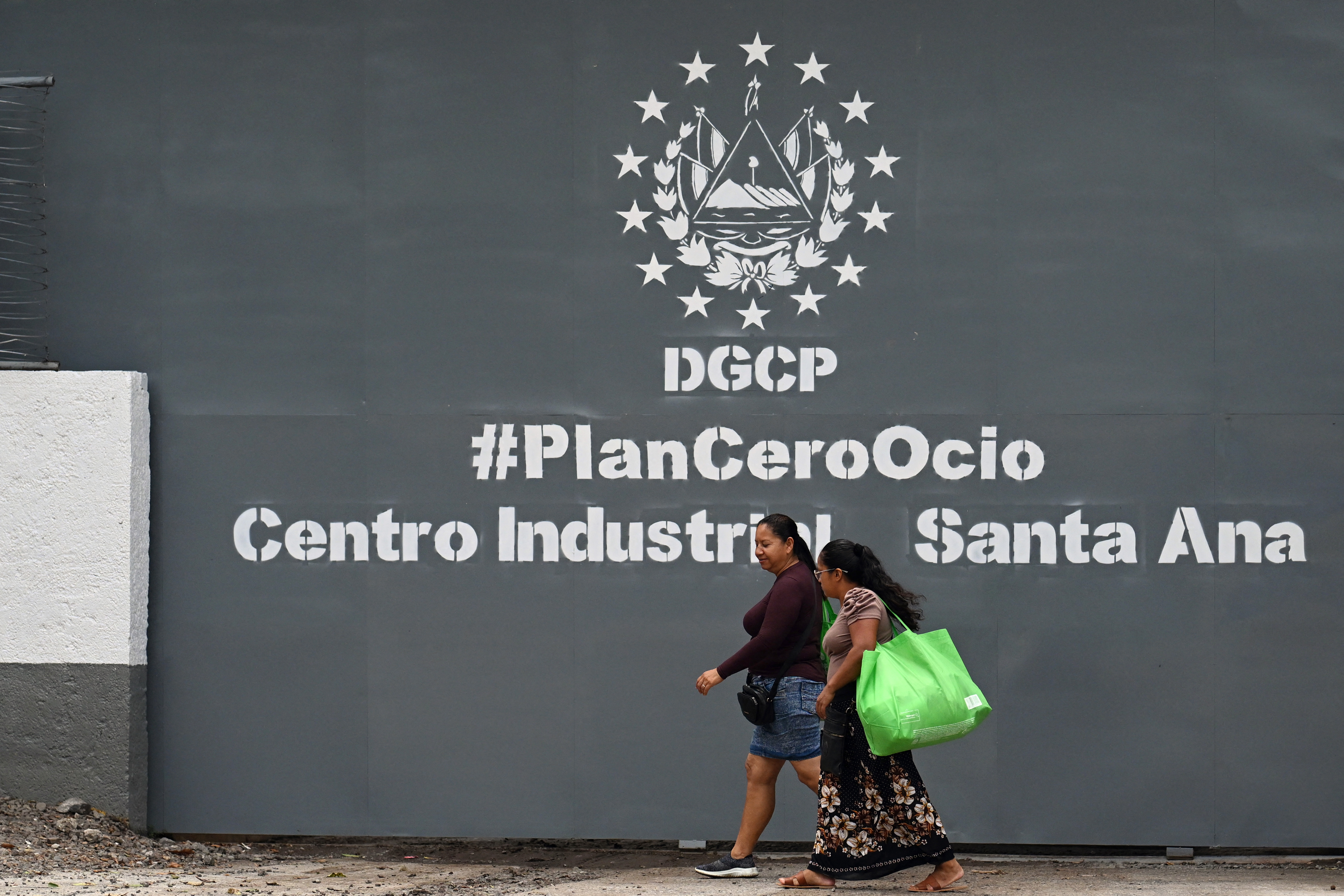 Two women walk in front of the Santa Ana Penitentiary Agricultural Industrial Complex, where Salvadoran deported migrant from the United States Kilmar Abrego García is reportedly imprisoned in Santa Ana, El Salvador on 22 April 2025. Abrego Garcia told US Senator Chris Van Hollen on April 17, that he was initially imprisoned at the Terrorism Confinement Center, a mega-prison for gang members, but was later transferred to a jail in the western department of Santa Ana. (Photo by Marvin RECINOS / AFP) (Photo by MARVIN RECINOS/AFP via Getty Images)