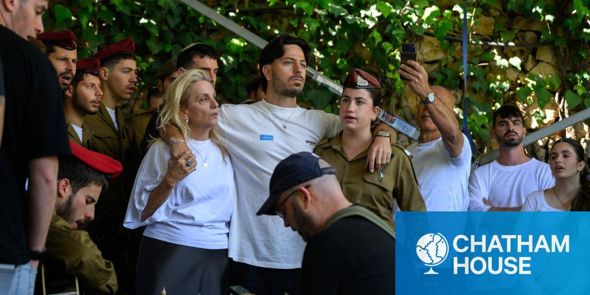 Israeli civilians and soldiers sing at a grave side in Jerusalem