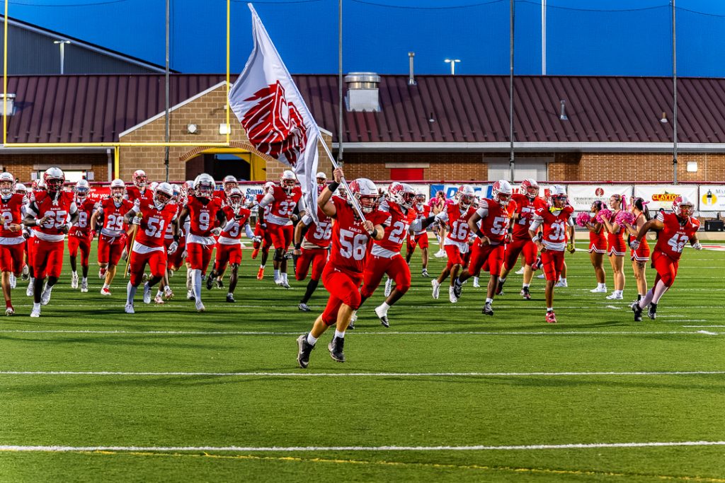 Junior Marquis Neal carries the Smyrna flag and leads the Eagles onto the field before the 2026 Harvest Bowl against the Middletown Cavaliers.