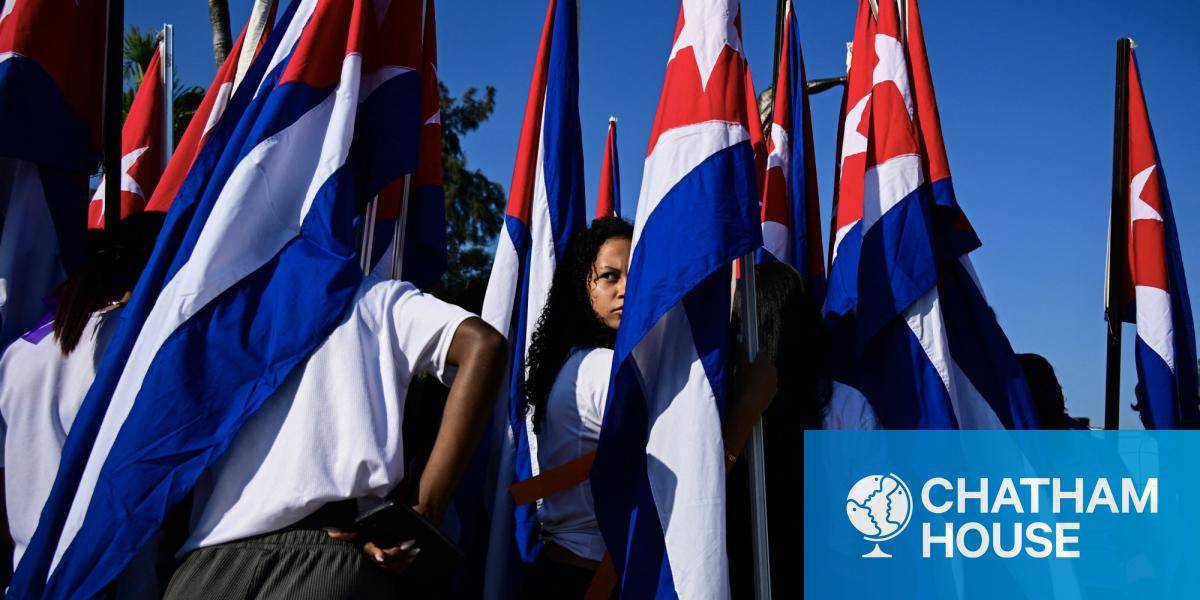 A woman looks on amid Cuban flags as she takes part in a demonstration against sanctions in Havana on 7 April 2026.