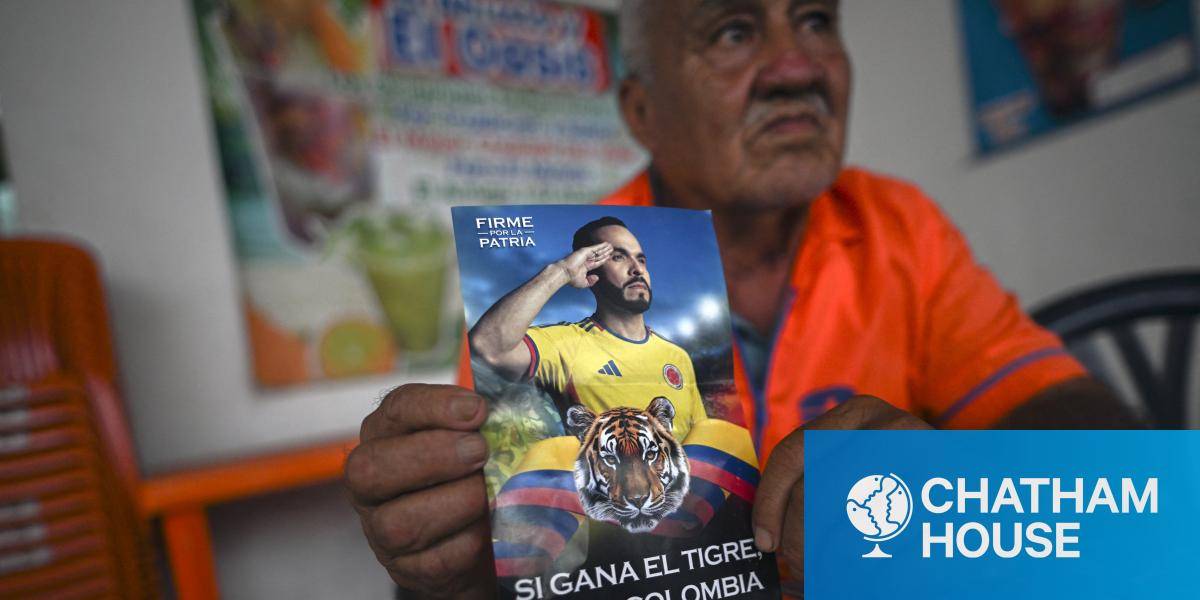 A man shows a flyer inviting people to vote for presidential candidate Abelardo de la Espriella, reading 'If the tiger wins, Colombia wins'