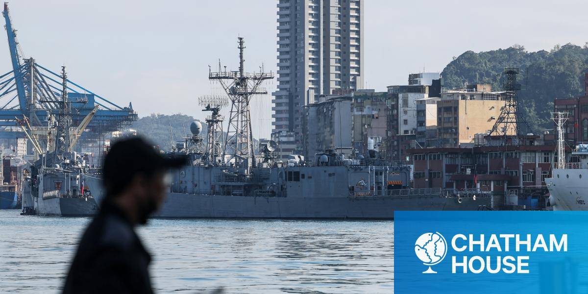 A man stands before Taiwanese Navy ships anchored at the harbour in Keelung. 