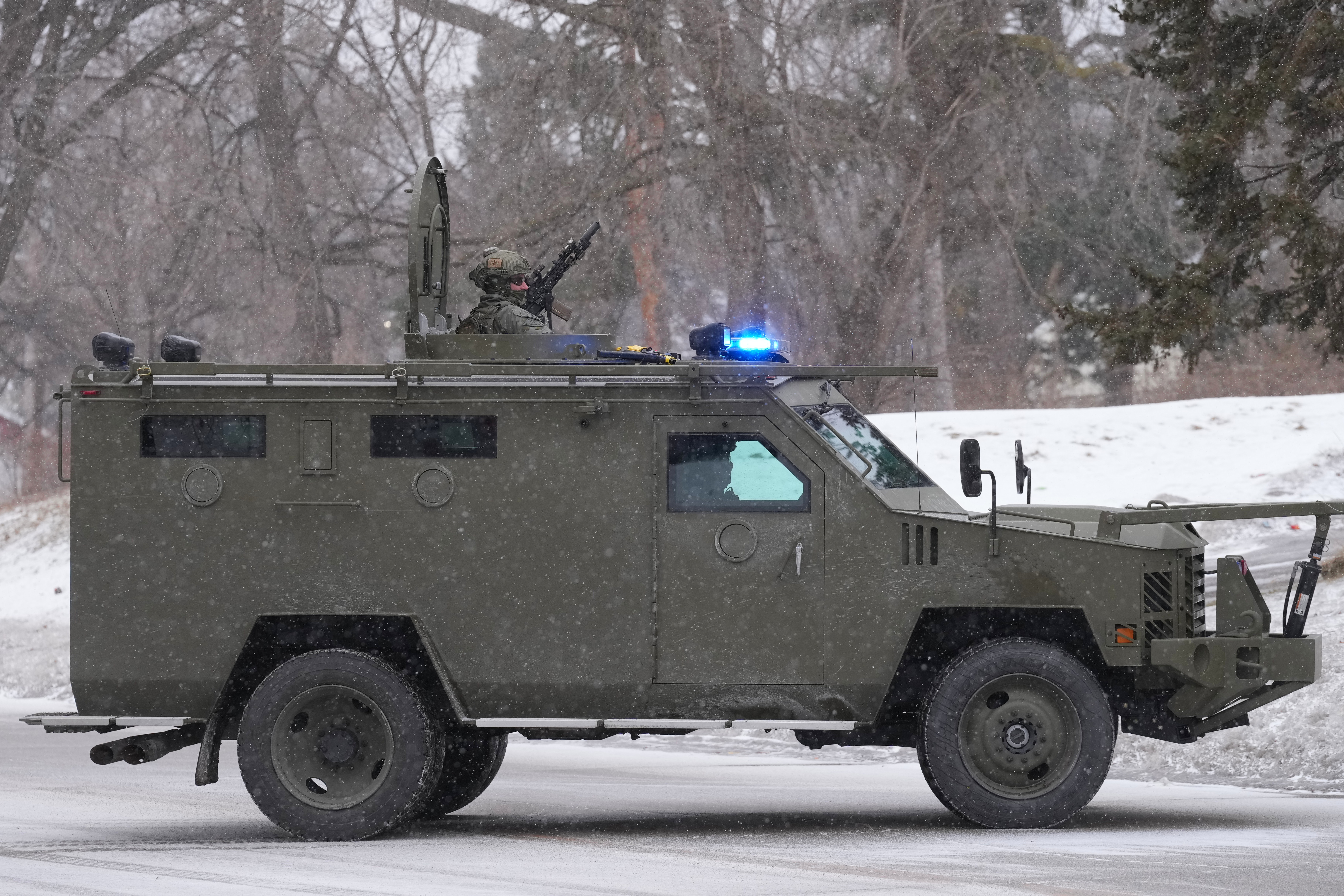 Federal agents ride in an armored vehicle during operations on Friday, Jan. 16, 2026, in St. Paul, Minn. (AP Photo/Adam Gray)