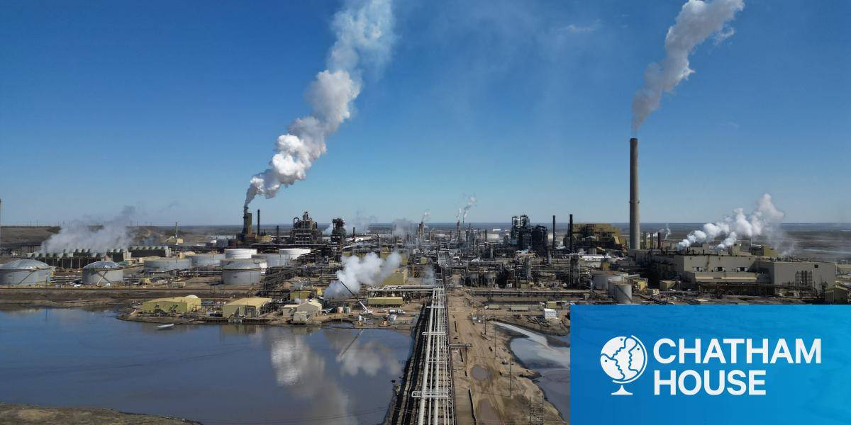 A view of the Syncrude refinery in Alberta, Canada, with smoking chimneys set against a blue sky