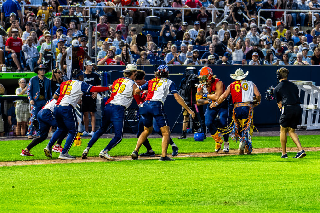 Tailgater Kyle Martin (No. 27) gets the handoff from his head coach on his way home after hitting a solo home run.