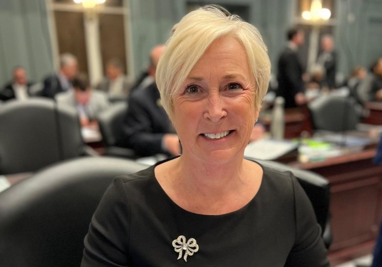 Rep. Ruth Briggs King smiles at her desk in Legislative Hall in 2023.