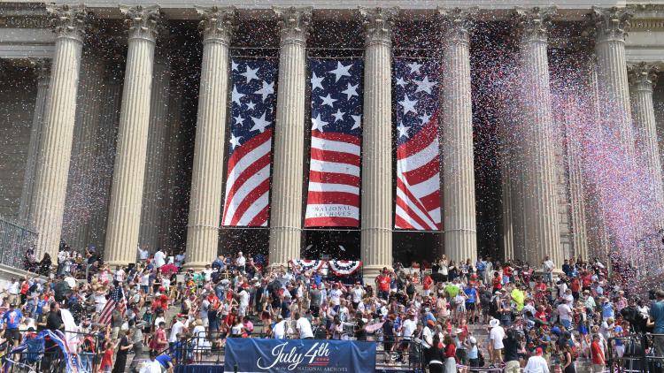 people celebrating 4th July in front of big building