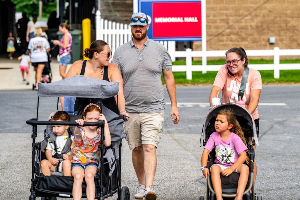 Bryan and Lauren Perkins walk with a friend while enjoying the fair with their children.