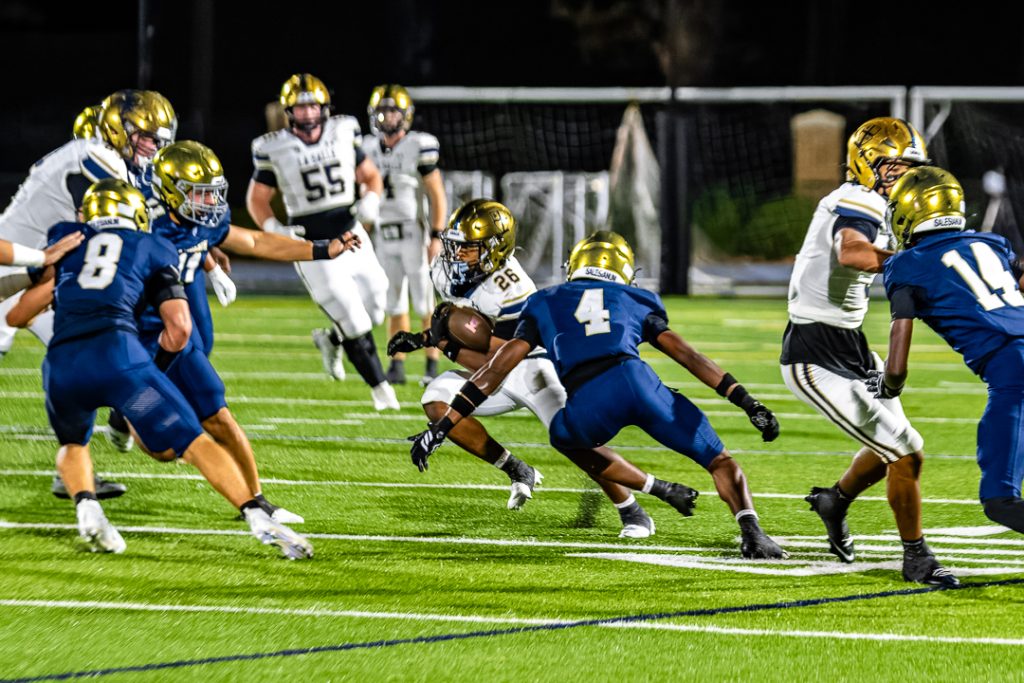 A group of Sallies defenders rally to tackle La Salle junior, Bryce Hanton. Hanton scored half of La Salle's touchdowns.
