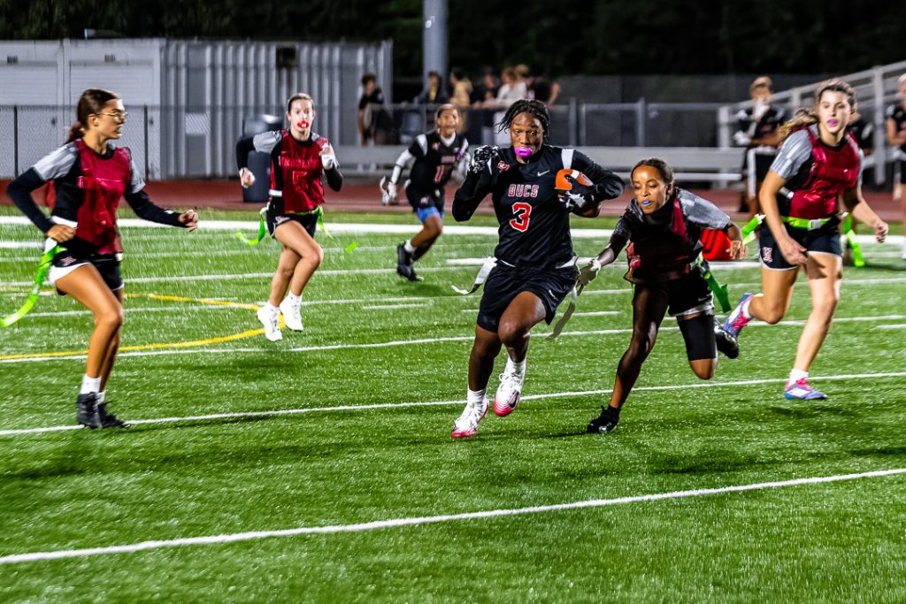 Ursuline freshman Amelia Douglas reaches out to pull Sudler's flag before she can break free.
