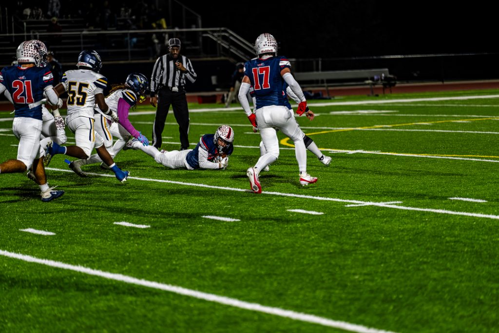 Patriot senior Chase Lednum dives on the football to recover the fumble for Newark Charter. The Patriots forced two turnovers in the first quarter of the game.