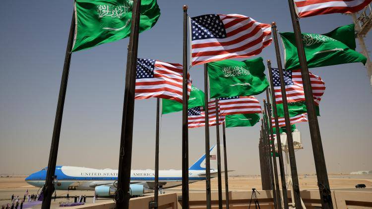 US and Saudi Arabian flags flutter in the foreground at King Khalid International Airport - with the Air Force One jet in the background