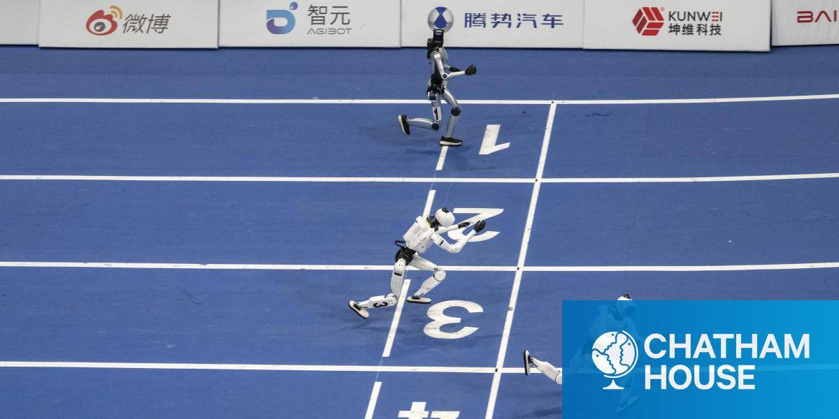 An aerial view of 4 humanoid robots racing on a blue track in Beijing, China.