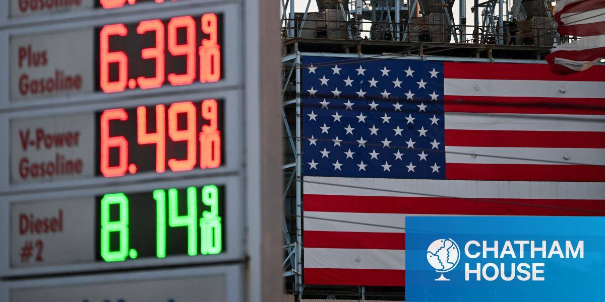 Gas prices at a Shell gas station above $6 a gallon for regular gasoline and $8 a gallon for diesel are displayed across from a US flag.