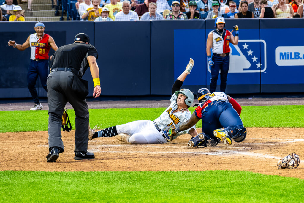 Coconut outfielder Gideon Antle (No. 18) just barely gets a hand in before the tag from Tailgater catcher Taj Porter (No. 26) winning the fourth inning for the Coconuts. They led, 2-1, through four innings.