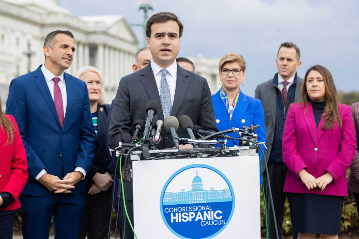 A man in a suit speaking at a podium.