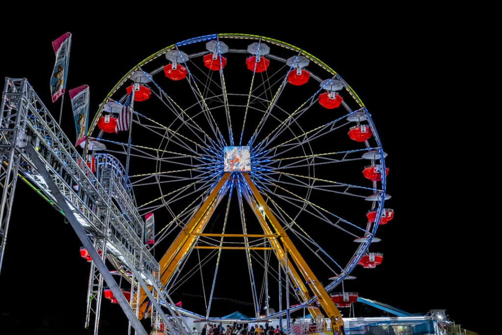 The ferris wheel lights up the night sky.