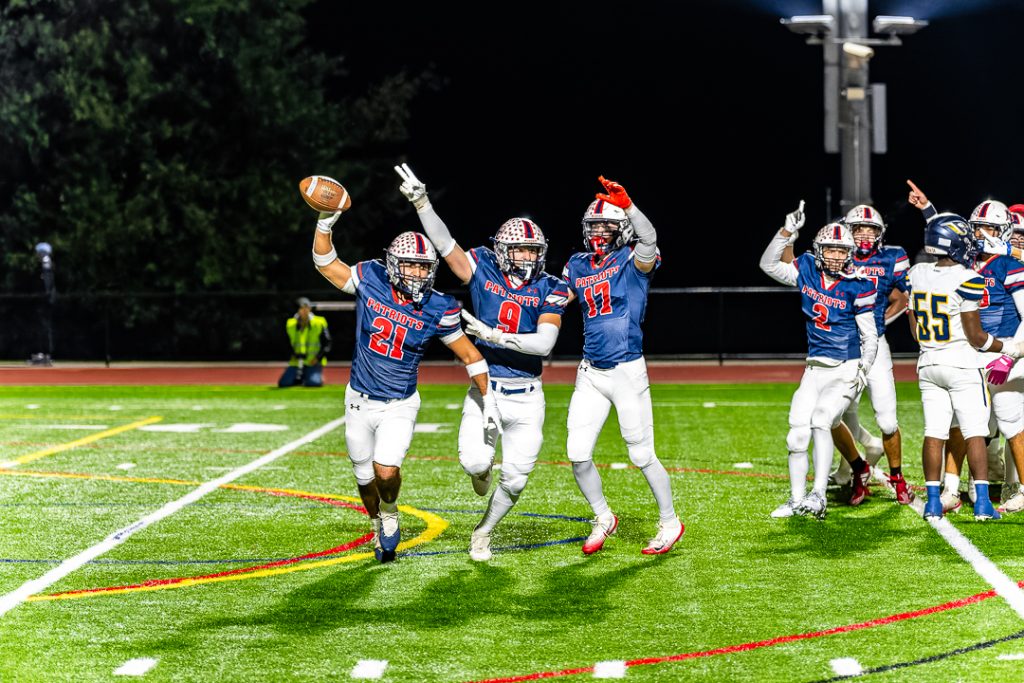 Junior Lucas Eruncak No. 21) celebrates with his teammates after recovering a fumble and returning possession back to the Patriot offense. 