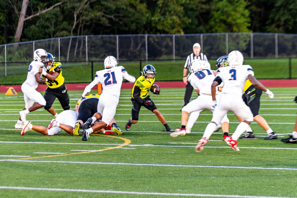 Ducks senior Nakai Hann runs the ball against Newark Charter's defense.