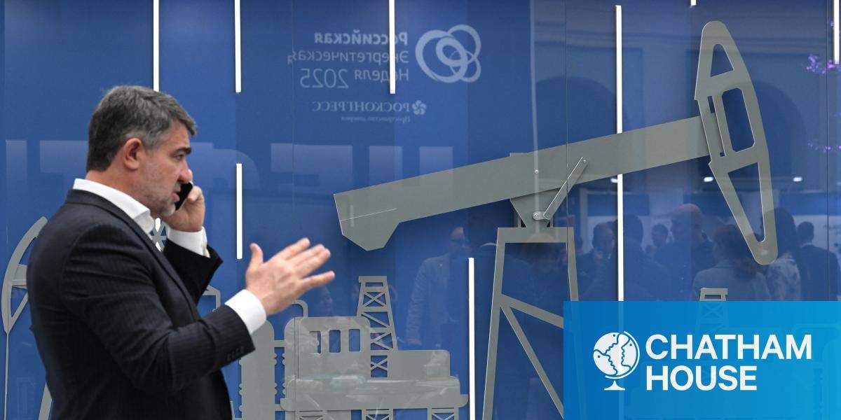 A man in front of an image of an oil pump