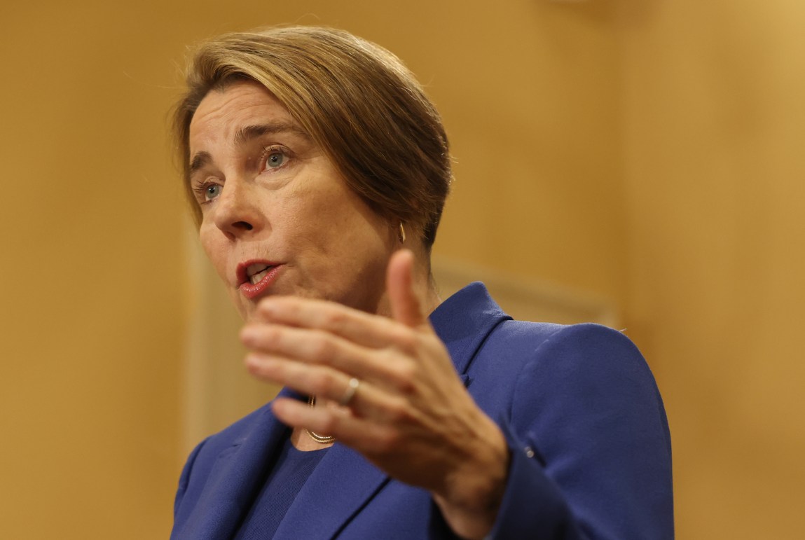A woman in a blue suit gestures with her hand while talking.