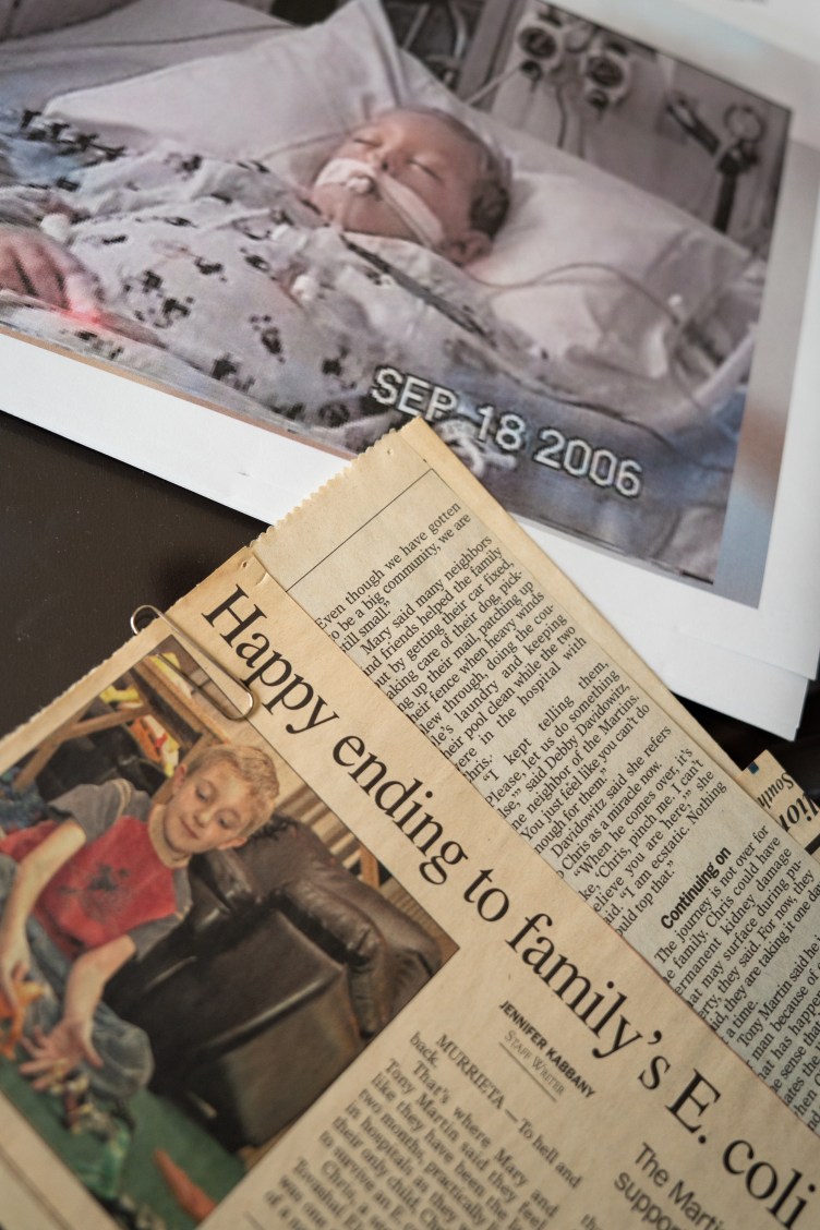  photograph of a boy in a hospital bed placed next to a newspaper clipping with the headline beginning, “Happy ending to family’s E. coli.”