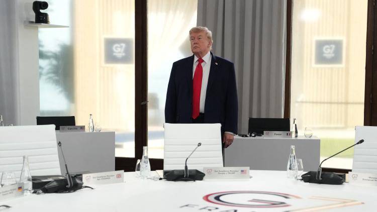 US President Donald Trump stands alone at a G7 conference table