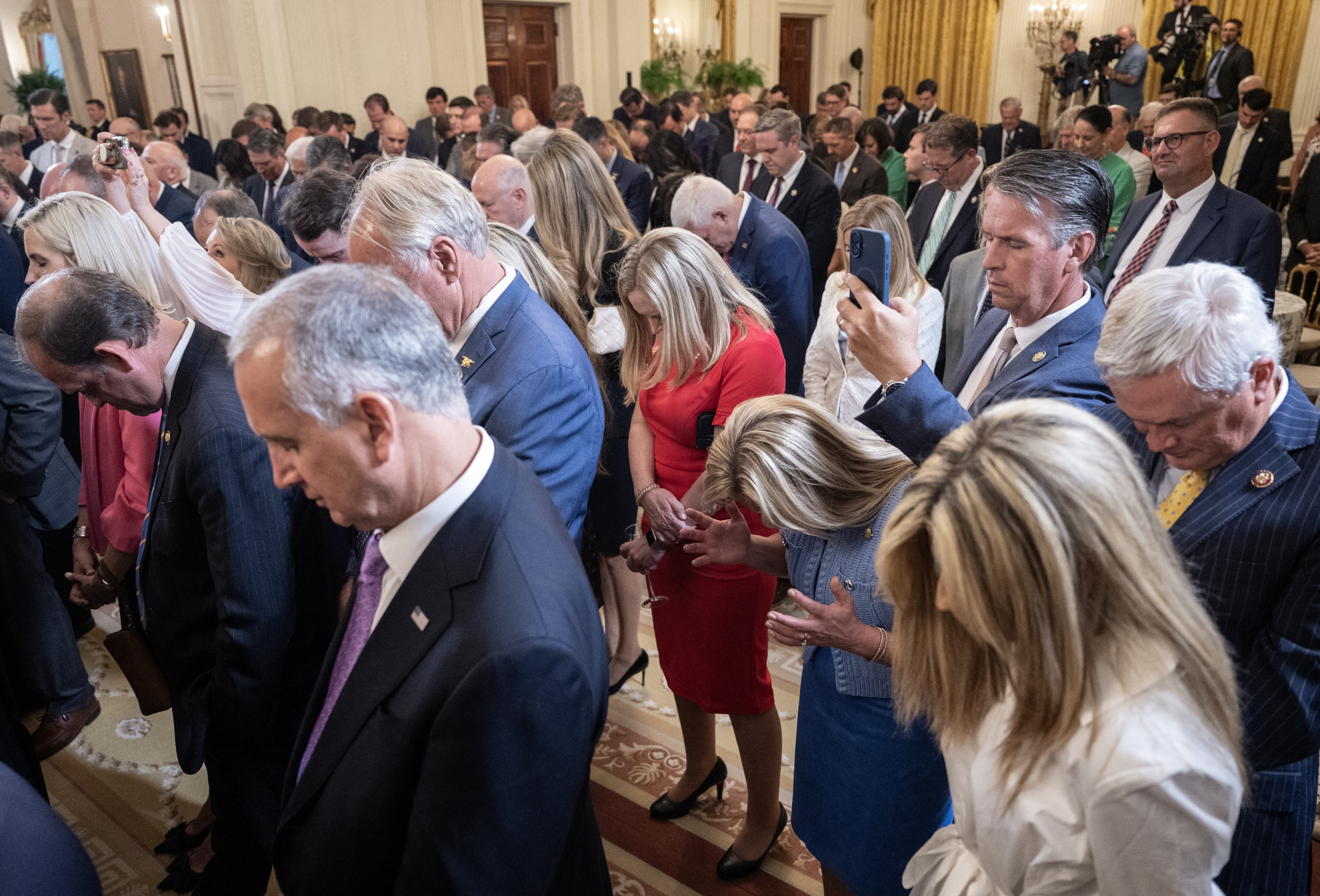 Attendees pray as unseen US Secretary of Housing and Urban Development Scott Turner prays for unseen US President Donald Trump during a reception with Republican members of Congress at the White House in Washington, DC on July 22, 2025. (Photo by ANDREW CABALLERO-REYNOLDS / AFP) (Photo by ANDREW CABALLERO-REYNOLDS/AFP via Getty Images)