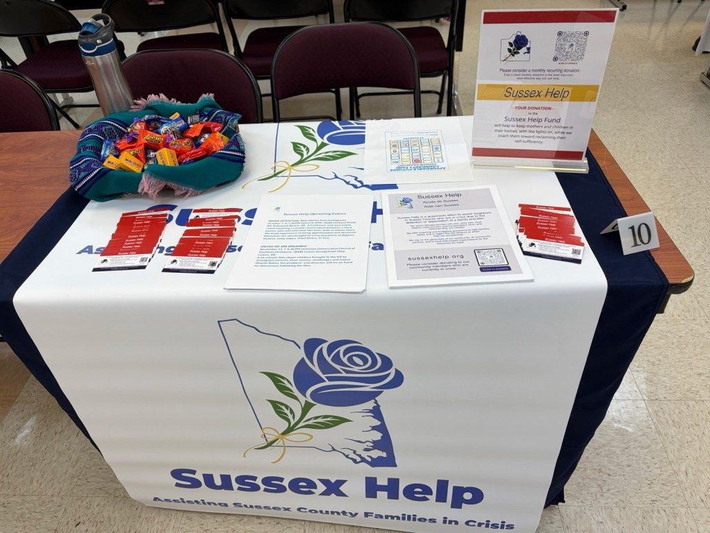 A table for Sussex Help includes pamphlets and other information for Delaware families impacted by a surge in ICE arrests.