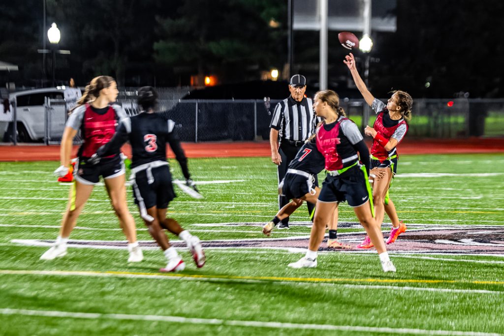 Raider senior Samantha Godfrey delivers a pass right before the Buccaneer defender can get her flag.