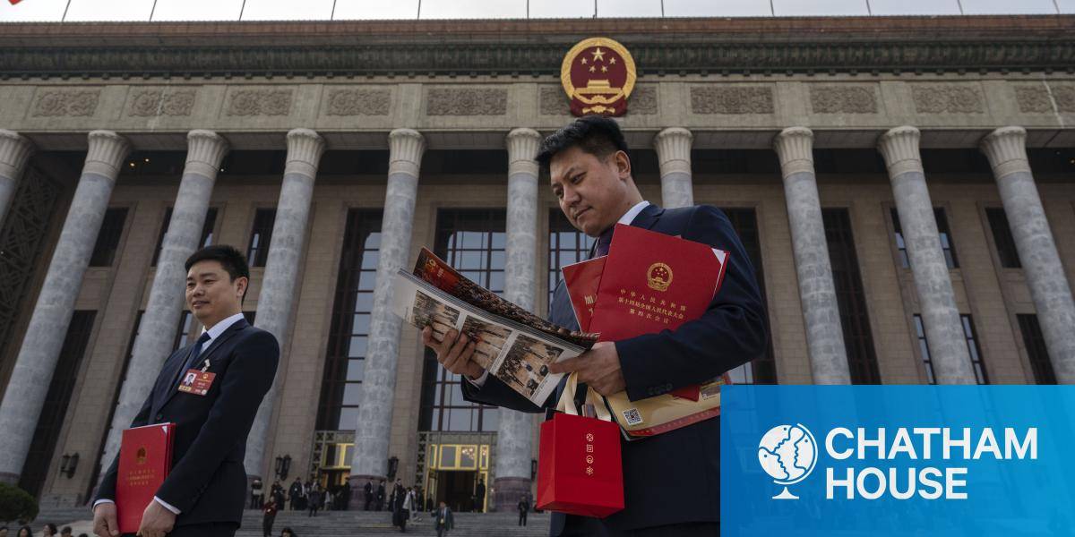 Delegates carry red books as they leave the closing session of the National People's Congress at the Great Hall of the People on 12 March 2026 in Beijing, China.