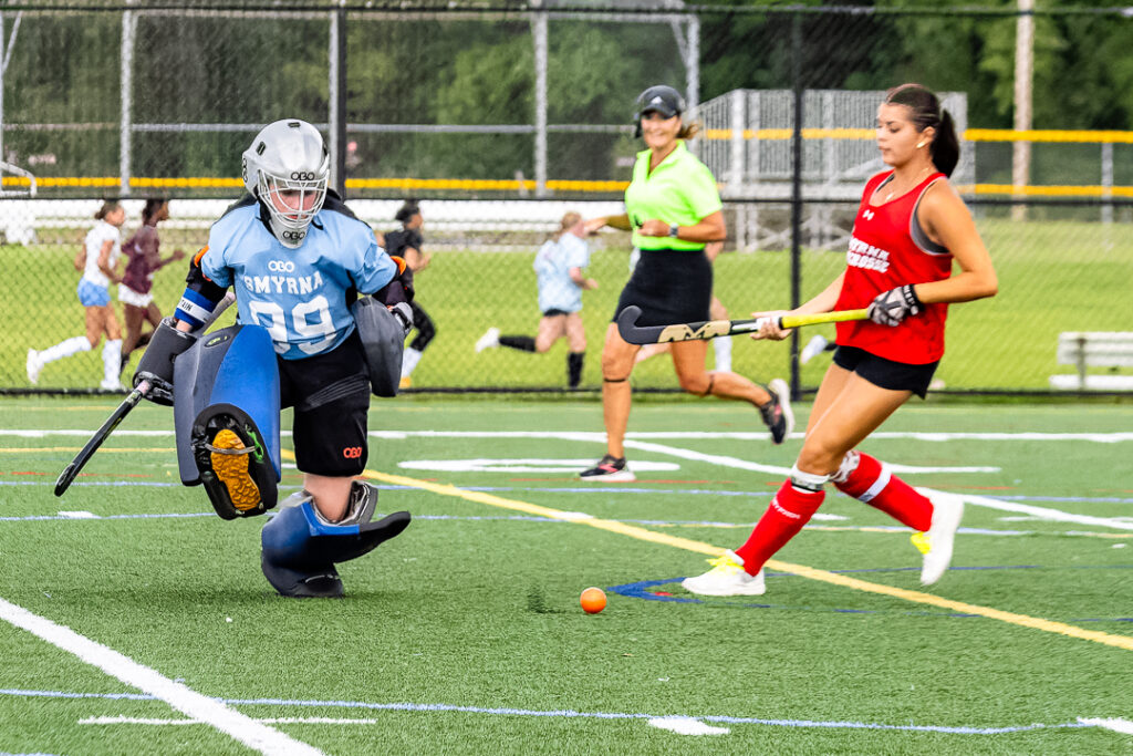 Smyrna's goalie makes the save and kicks the ball away from the cage.