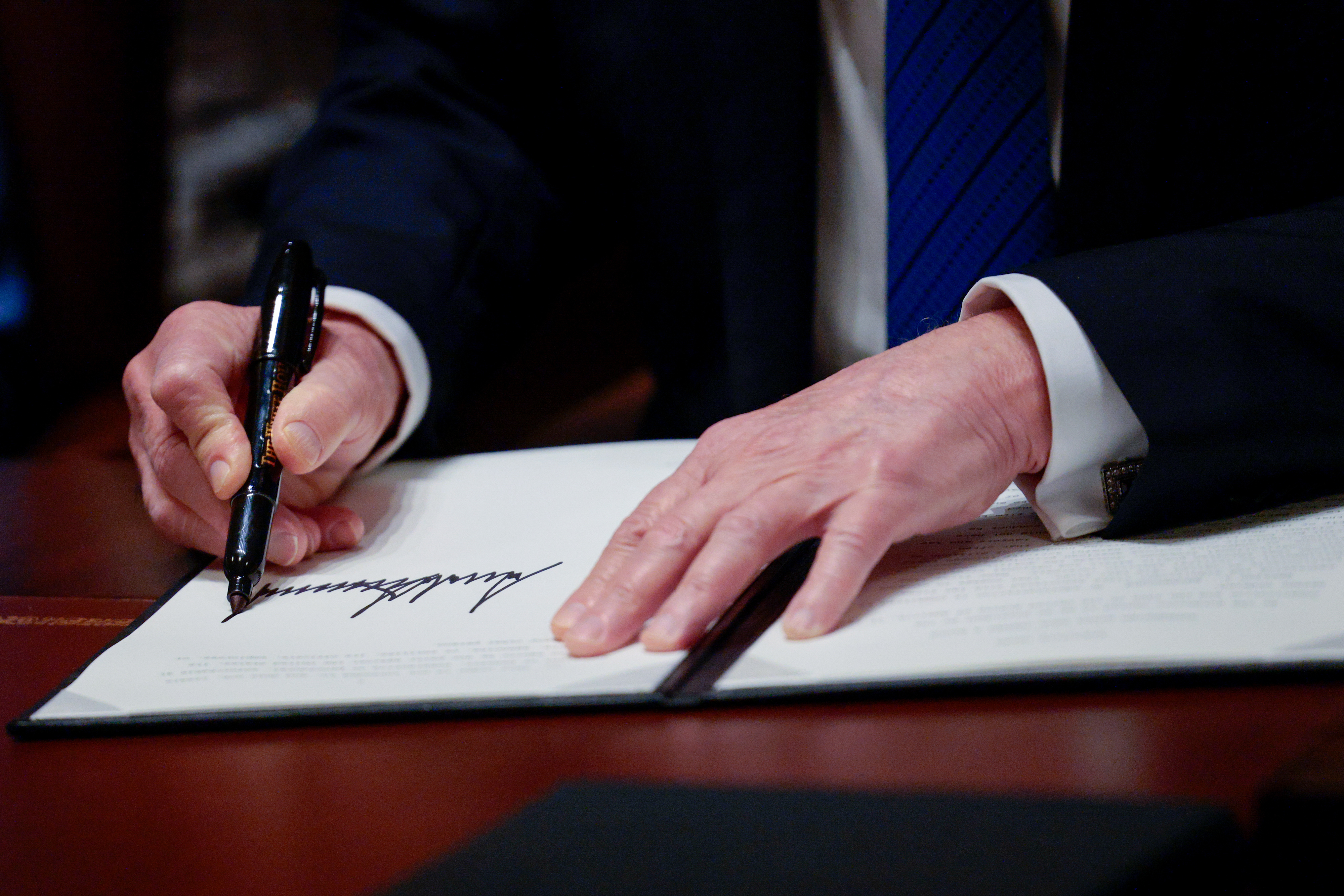 US President Donald Trump signs an executive order during a US ambassadors meeting in the Cabinet Room of the White House in Washington, DC, US, on Tuesday, March 25, 2025. Trump directed the Treasury Department to modernize and centralize its payment system in an effort to root out fraud as money is transferred throughout the federal government. Photographer: Shawn Thew/EPA/Bloomberg via Getty Images