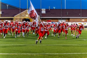 Junior Marquis Neal carries the Smyrna flag and leads the Eagles onto the field before the 2026 Harvest Bowl against the Middletown Cavaliers.