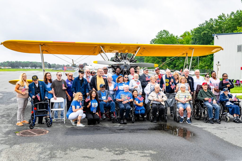 The group of veterans honored during the Dream Flight event pose for a group photo along with their care team members from the Delaware Health Care Facilities Association.