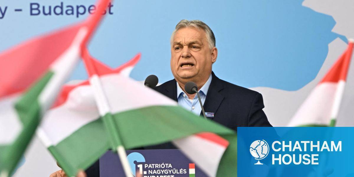 Hungarian Prime Minister Viktor Orban addresses a rally, with Hungarian flags waving in the foreground
