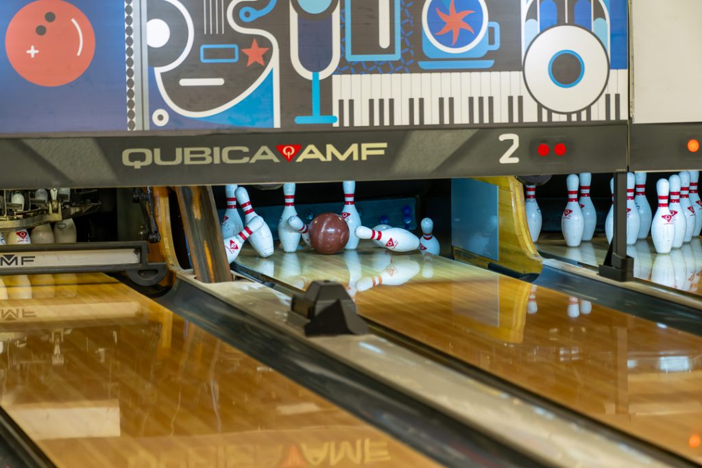 The ball hits the pins perfectly, resulting in a strike.