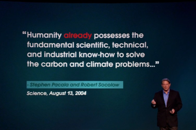 Al Gore stands in front of a screen with a quote saying, “Humanity already possesses the fundamental scientific, technical, and industrial know-how to solve the carbon and climate problems … .” The quote is attributed to Stephen Pacala and Robert Socolow in Science on Aug. 13, 2004.
