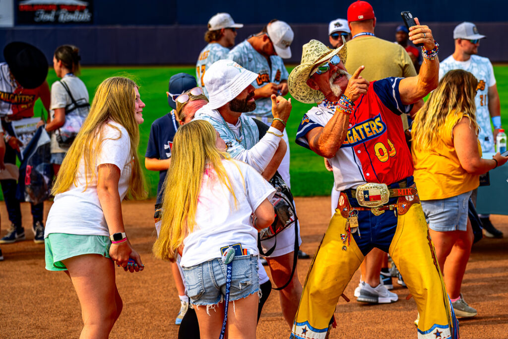 Tailgater head coach Joe Mikulik (No. 00) and Coconuts assistant coach Anthony Marks pose for a selfie with a group of fans on the field pregame.
