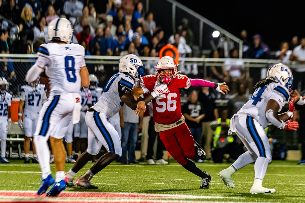 Middletown quarterback, Max Phipps, surveys the field as the Smyrna pass rush attempts to get passed the Middletown offensive line.