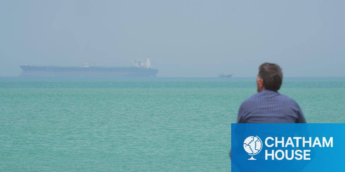 A man looks at shipping in the Strait of Hormuz