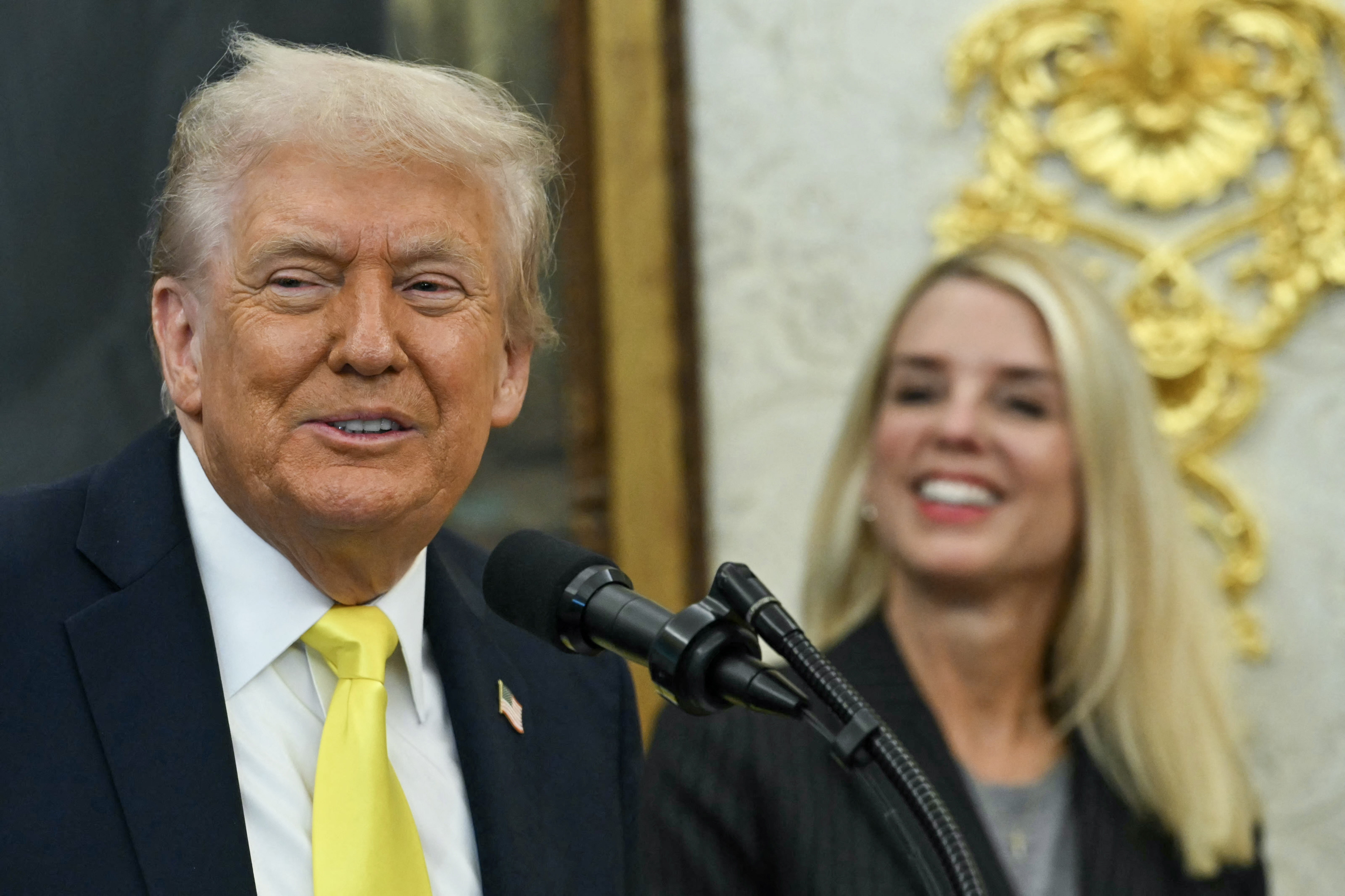 US President Donald Trump speaks as Attorney General Pam Bondi smiles during a press conference in the Oval Office of the White House in Washington, DC, on October 15, 2025. (Photo by ANDREW CABALLERO-REYNOLDS / AFP) (Photo by ANDREW CABALLERO-REYNOLDS/AFP via Getty Images)