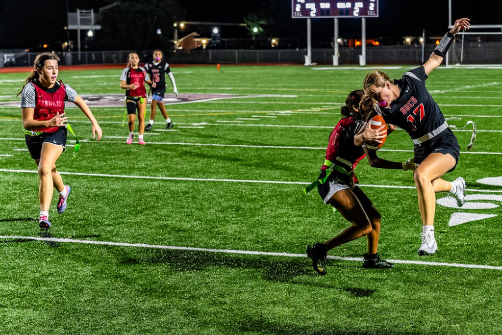 Caravel junior Katie Pinand tries to avoid her flag being pulled as she runs down the sideline.